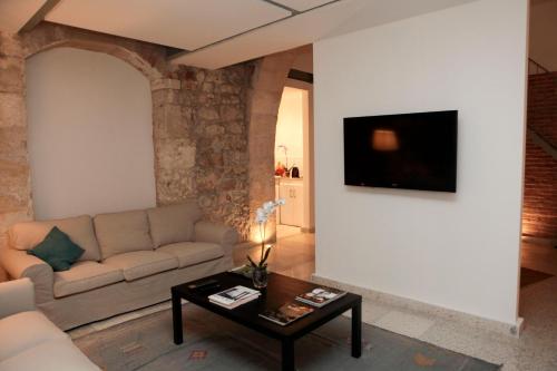 ein Wohnzimmer mit einem Sofa und einem Tisch in der Unterkunft La Casa Sulla Darsena in Syrakus