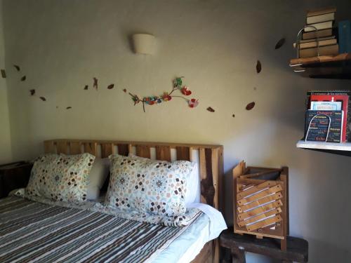 a bedroom with a bed with leaves on the wall at Jacamaki Nature GuestHouse en Villa de Leyva in Villa de Leyva