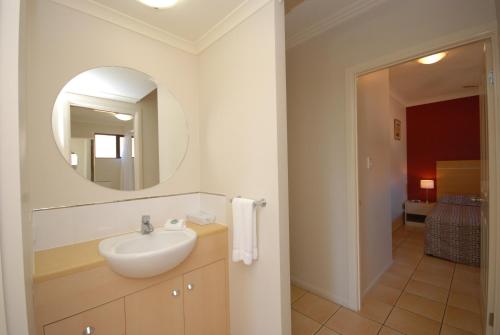 a bathroom with a sink and a mirror at City Plaza Apartments in Cairns