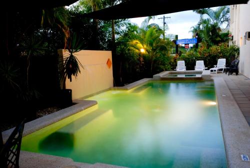 a swimming pool in a backyard with chairs around it at City Plaza Apartments in Cairns