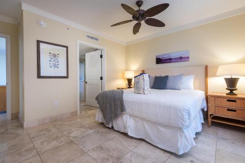 a bedroom with a white bed and a ceiling fan at Honua Kai - Hokulani 509 - Ocean view from INSIDE! 2b/2b in Kaanapali