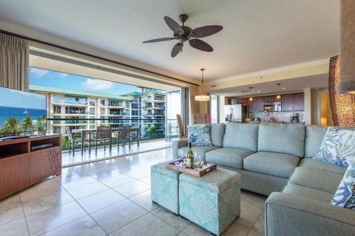 a living room with a couch and a large window at Honua Kai - Hokulani 509 - Ocean view from INSIDE! 2b/2b in Kaanapali