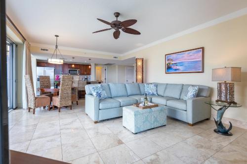a living room with a blue couch and a table at Honua Kai - Hokulani 509 - Ocean view from INSIDE! 2b/2b in Kaanapali