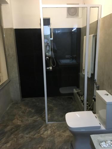 a bathroom with a toilet, sink, and shower stall at Dumbara Peak Residence in Kandy