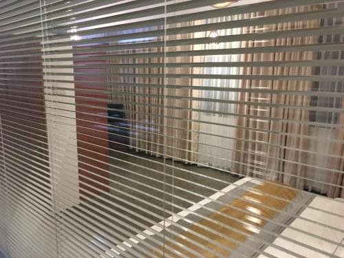 a window with blinds on it with a view of a building at Dumbara Peak Residence in Kandy