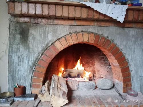 a brick oven with a fire in it at L House in Tʼelavi