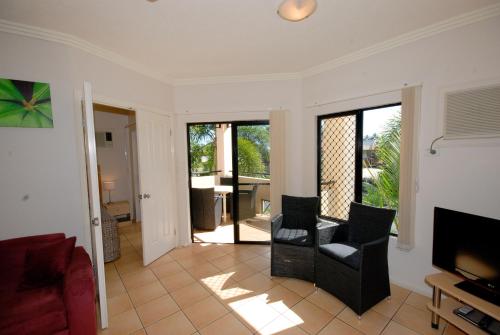 a living room with two chairs and a television at City Plaza Apartments in Cairns