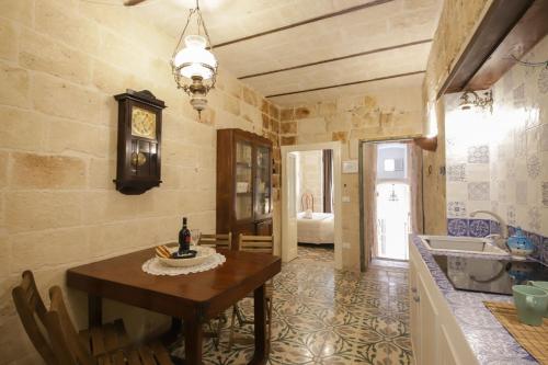 a kitchen with a table and a clock on the wall at HolidayMonopoli in Monopoli