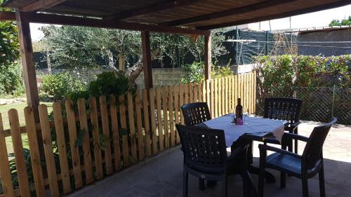 a table with chairs and a bottle of wine on a patio at Casa Magnolia in Arena Metato