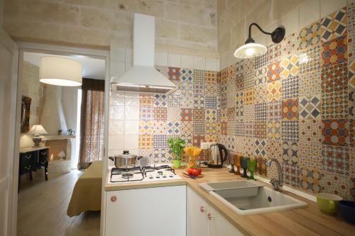 una cucina con lavello e fornello forno superiore di HolidayMonopoli a Monopoli