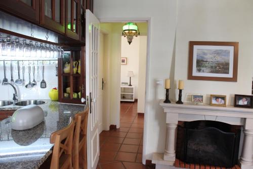 a kitchen with a fireplace and a living room at Apartamento de São João in Praia da Areia Branca