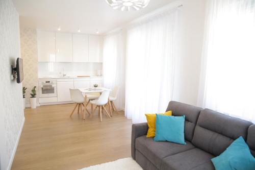 ein Wohnzimmer mit einem grauen Sofa und einem Tisch in der Unterkunft Apartament Plażowy in Giżycko