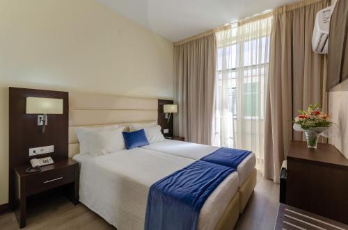 a hotel room with a large bed and a window at Hotel LX Rossio in Lisbon