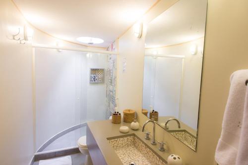 a bathroom with a large mirror and a sink at Pousada da Cyssa in Búzios