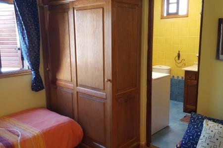 a bedroom with a bed and a wooden closet at Casita Playa La Salemera (Mazo) in Malpaíses