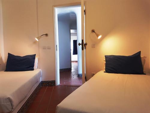 a room with two beds and a door leading to a hallway at Apartamentos Turisticos Soldoiro in Albufeira