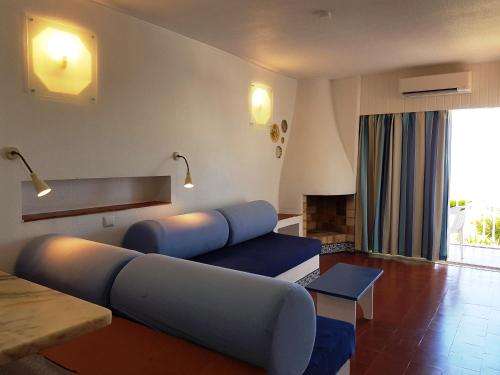 a living room with a blue couch in a room at Apartamentos Turisticos Soldoiro in Albufeira