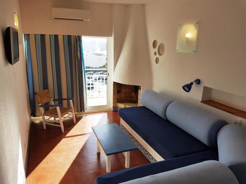 een woonkamer met een blauwe bank en een raam bij Apartamentos Turisticos Soldoiro in Albufeira