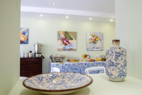 uma cozinha com uma mesa com um prato e um vaso em Aphrodite Hotel Syros em Kinion