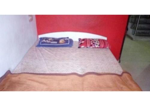 a bed in a room with a red wall at D.C hotel in Chittaurgarh