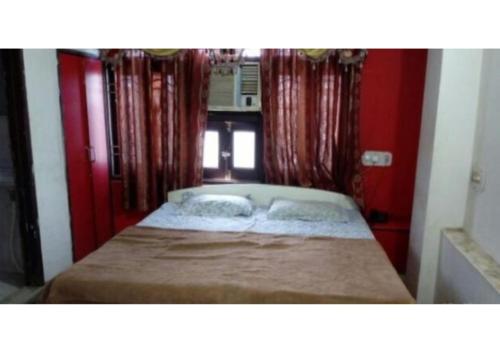 a small bed in a room with red walls at D.C hotel in Chittaurgarh
