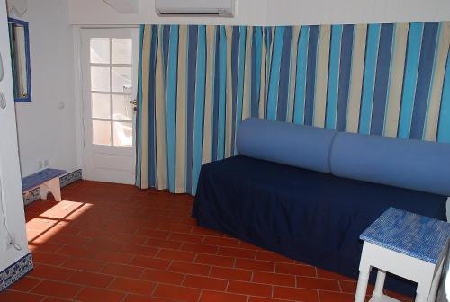 a living room with a blue bed and a window at Apartamentos Turisticos Soldoiro in Albufeira
