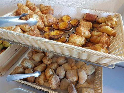 two baskets filled with different types of bread and pastries at Apartamentos Turisticos Soldoiro in Albufeira