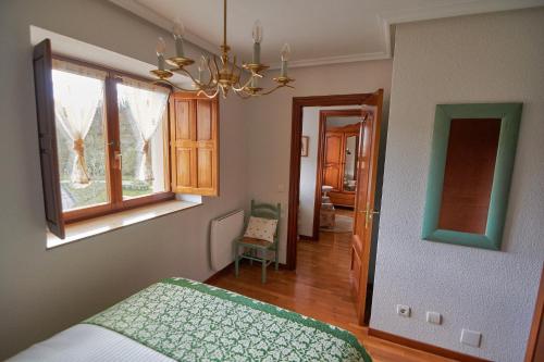 a bedroom with a bed and a window and a chandelier at Casa Pichi in El Pulliu