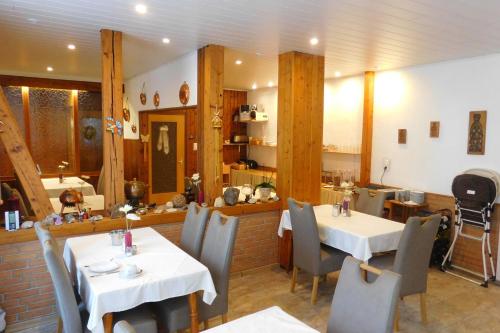 een restaurant met 2 tafels en stoelen in een kamer bij Hotel Pension am Kurmittelhaus in Bad Grund