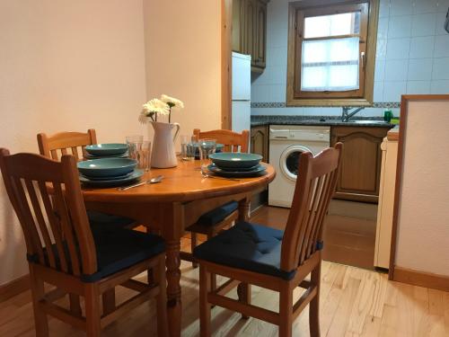 a kitchen with a wooden table with chairs and a dining room at BPIRINEOS-Tuca de Ixeia in Benasque