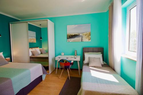 a bedroom with two beds and a desk and a mirror at Apartman Nicole in Mošćenička Draga