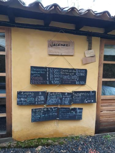 a wall with signs on the side of a building at Jacamaki Nature GuestHouse en Villa de Leyva in Villa de Leyva