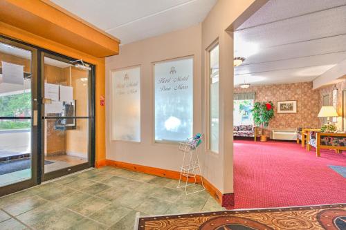 a room with a red carpet and a glass door at Hotel Motel Penn-Mass in Trois-Rivières