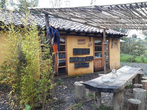 a small building with a table in front of it at Jacamaki Nature GuestHouse en Villa de Leyva in Villa de Leyva