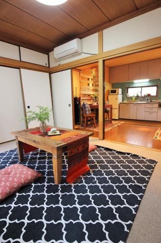 a living room with a table and a kitchen at Koi Koi in Takamatsu