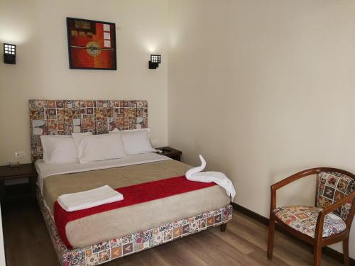 a small bedroom with a bed and a chair at Cordoba Suites in Hurghada