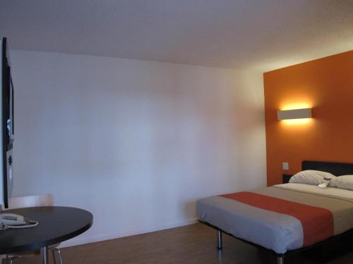 ein Hotelzimmer mit einem Bett und einem Tisch in der Unterkunft Motel 6 Baltimore MD in Baltimore