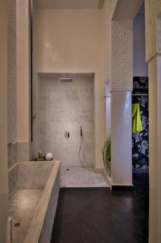 a large bathroom with a tub and a shower at Dar Kandi in Marrakech