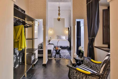 a hotel room with a bedroom with a bed and chairs at Dar Kandi in Marrakech