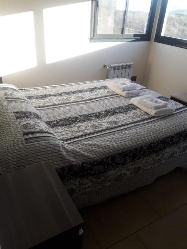 a bed in a bedroom with two towels on it at Complejo Megevand in Río Ceballos