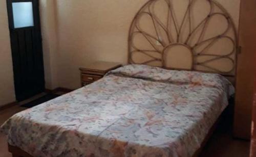 a bedroom with a bed with a large headboard at Hotel Canadá in Toluca