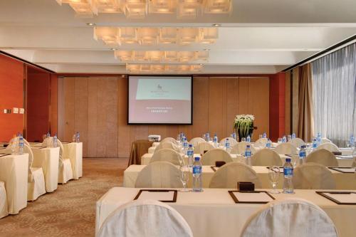 a conference room with white tables and a projection screen at Marco Polo Parkside, Beijing in Beijing