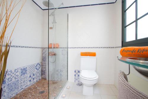 uma casa de banho com um WC e uma cabina de duche em vidro. em Casa Hibiscus em Punta Mujeres