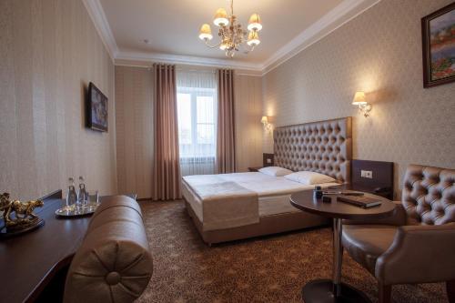 a hotel room with a bed and a couch at Hotel Legenda in Rostov on Don