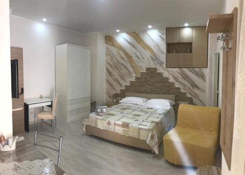 ein Schlafzimmer mit einem Bett und einer Steinmauer in der Unterkunft Bed and Breakfast La Volpe Rossa in Regalbuto