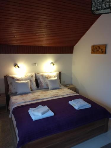 a bedroom with a large bed with two towels on it at Apartment Arya in Korenica