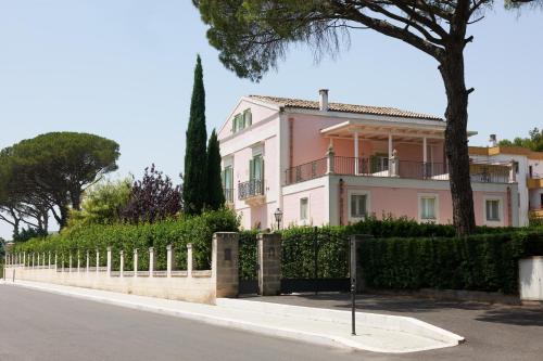 a pink house with a fence in front of a street at Hotel Casino Ridola in Matera