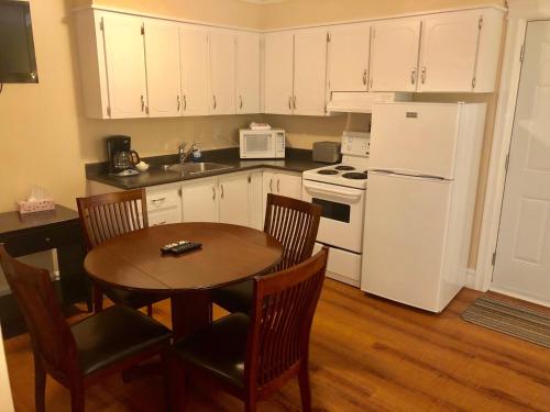 eine Küche mit einem Tisch und einem weißen Kühlschrank in der Unterkunft Arnold's Cove Inn in Arnold's Cove