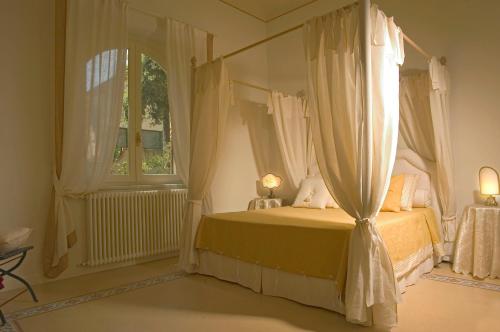 a bedroom with a bed with curtains and a window at Villa Signori in Marina di Pietrasanta