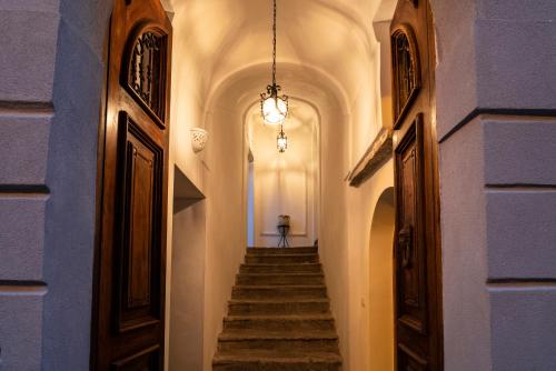 un couloir avec des escaliers et un lustre dans l'établissement Residenza d'epoca Olimpia, à Santa Maria di Castellabate